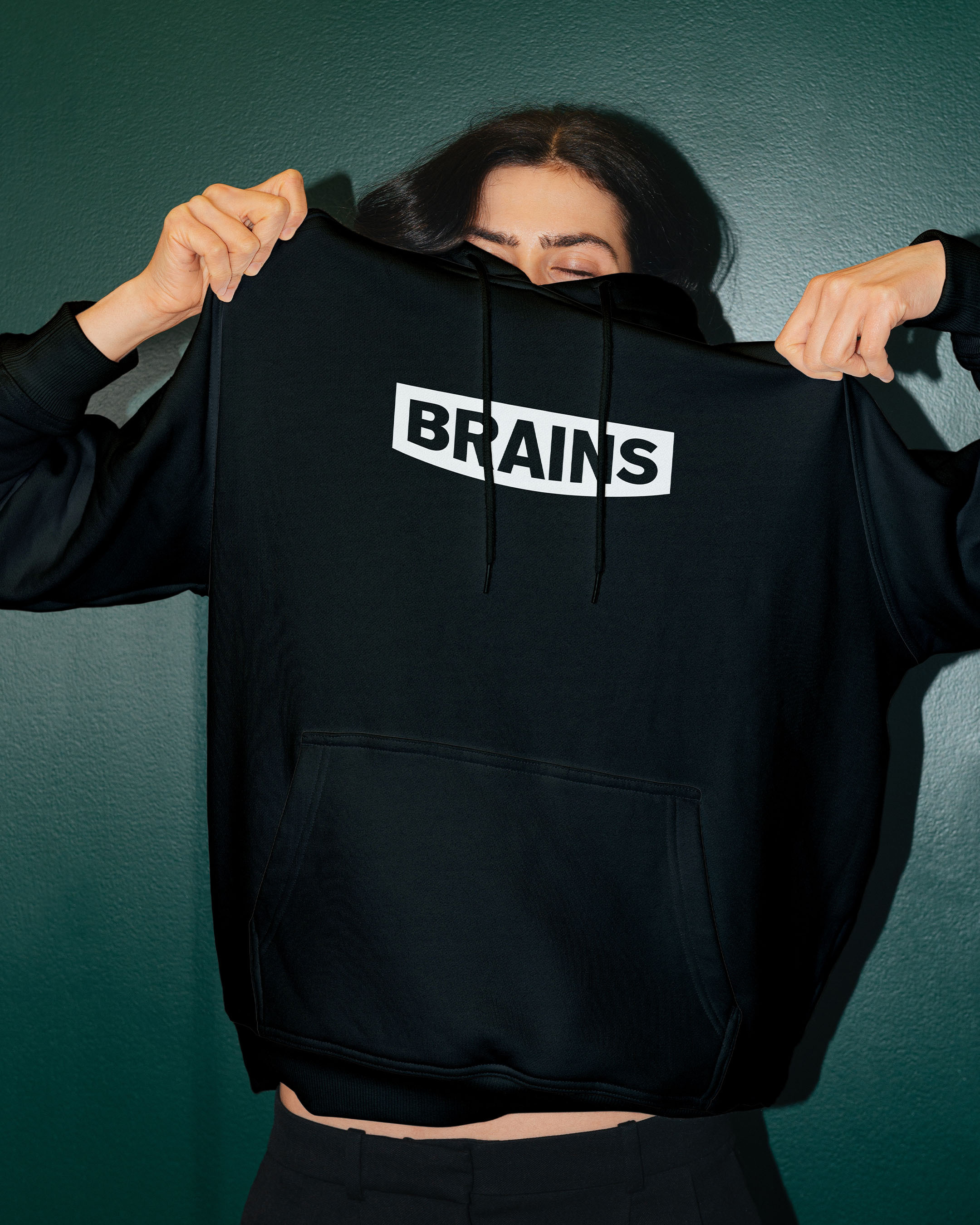 A woman putting on a hoodie with the Brains logo on