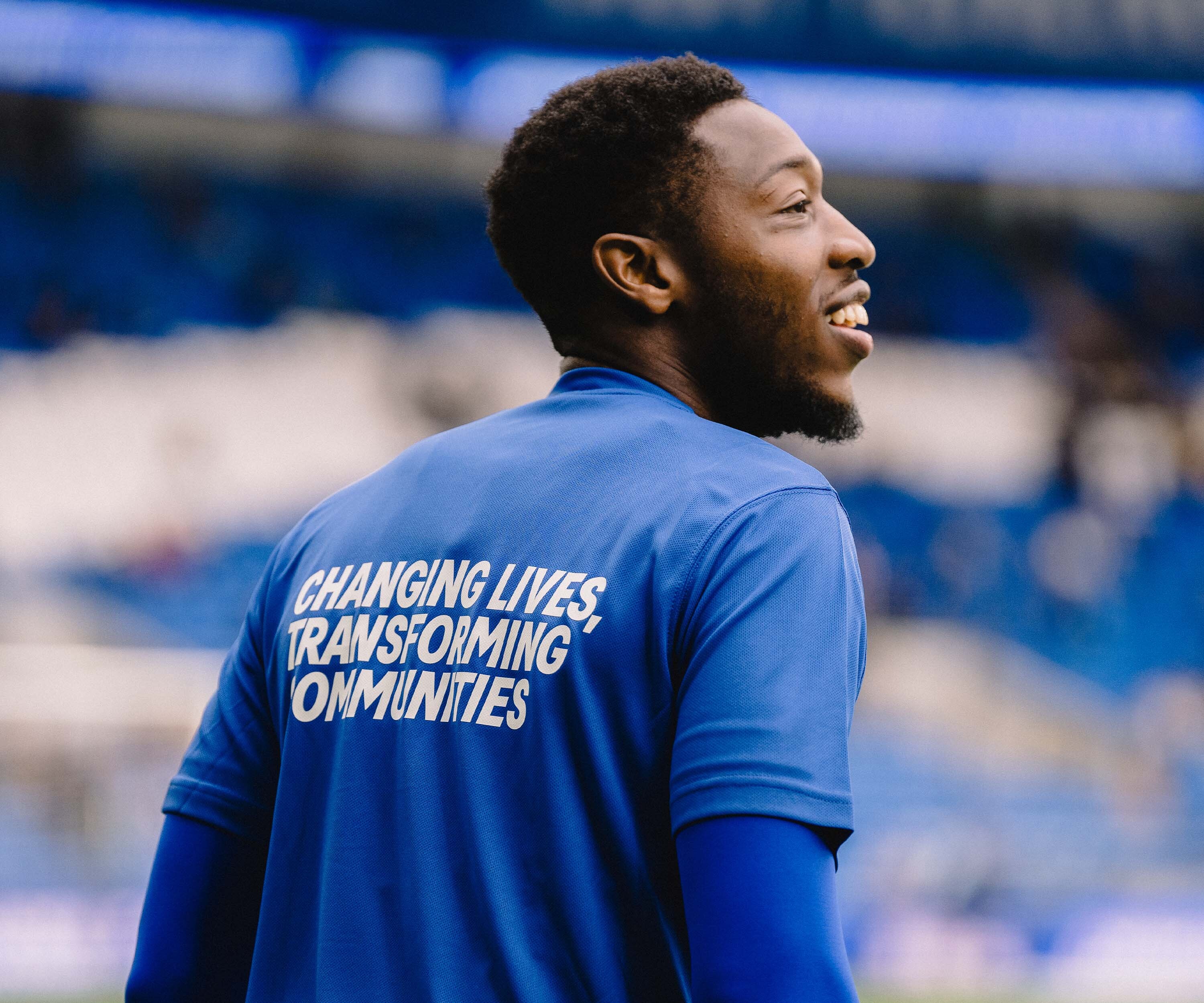 cardiff city fc player ebou adams wearing a branded community foundation t shirt