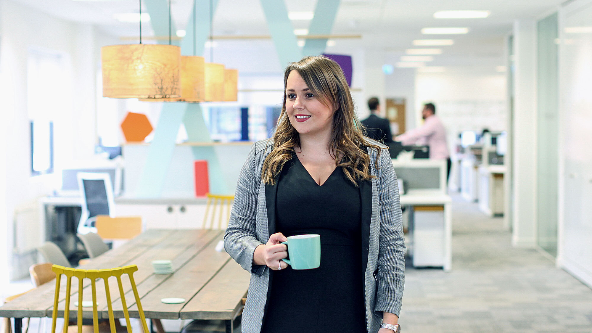 A woman holding a mug in the Yolk office